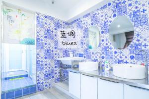 重慶市にある弱水咖啡国际青旅 Only Cafe and Backpackerの青と白のバスルーム(シンク、鏡付)