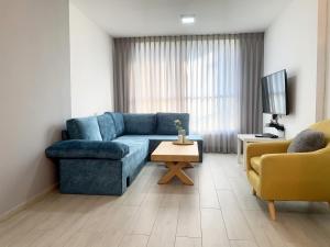 a living room with a blue couch and a tv at Mor's Place in Beer Sheva