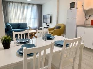 Mor's Place في بئر السبع: مطبخ وغرفة معيشة مع طاولة وكراسي