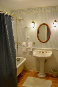 a bathroom with a sink and a tub and a mirror at Victorian by the Sea in Lincolnville