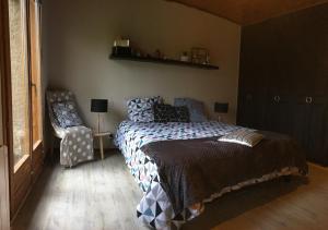 - une chambre avec un lit et une chaise dans l'établissement Un petit coin d’Alsace, à Soultzmatt