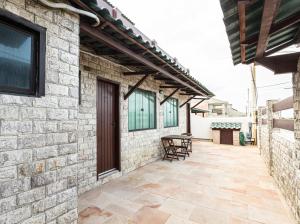 a patio with a table and chairs on a building at Pousada Casa do Telhado Verde in Cabo Frio