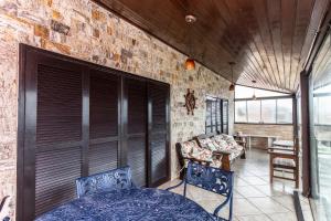 un porche cubierto con 2 sillas y una mesa en Pousada Casa do Telhado Verde, en Cabo Frío