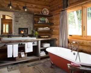 a bathroom with a tub and a fireplace at Lone Mountain Ranch in Big Sky