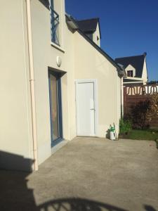 a white house with a white door in a yard at Voltaire in La Turballe