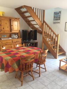 a kitchen with a table and chairs and a staircase at Voltaire in La Turballe
