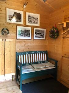 a wooden bench in a room with pictures on the wall at Zirbelhütte in Hohentauern