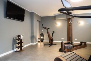 een fitnessruimte met 2 hometrainers en een flatscreen-tv bij Villa am Park in Binz