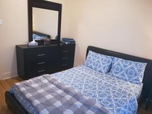 Un dormitorio con una cama con una cómoda y un espejo. en Montreal Authentic appartment, en Montreal