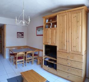a kitchen with a large wooden cabinet and a table at Duplex à la Moutière in Tignes