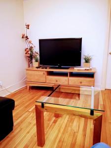 Una sala de estar con un televisor de pantalla plana sobre una mesa. en Montreal Authentic appartment, en Montreal