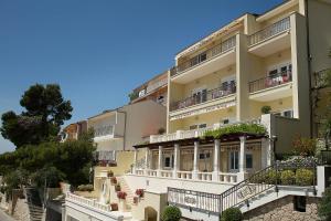 a large apartment building with balconies and stairs at Villa King Apartments in Brela