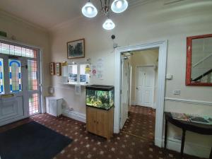 a living room with a fish tank on a wooden stand at The Handforth Lodge in Handforth