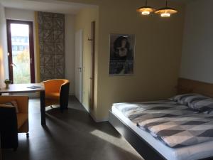 een slaapkamer met een bed, een bureau en een raam bij Appartements am Bauhaus in Dessau