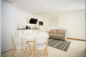 een woonkamer met een tafel en stoelen en een bank bij Apartamento Casino Praia IV in Figueira da Foz