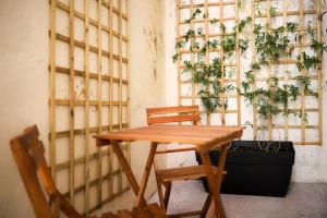 een houten tafel en stoelen in een kamer met planten bij Apartamento Casino Praia IV in Figueira da Foz