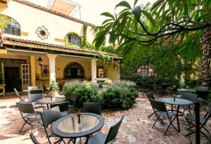 un patio con tavoli e sedie di fronte a un edificio di Casa de la Noche a San Miguel de Allende