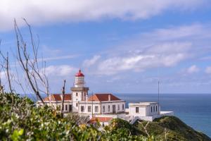 a building with a lighthouse on top of the ocean at Apartamento Casino Praia IV in Figueira da Foz