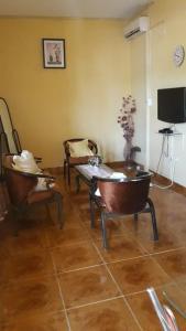 uma sala de estar com cadeiras, uma mesa e uma televisão em Afilux Residencial em Luanda