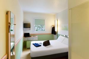 a hotel room with a white bed and a window at Ibis Budget Bilbao Arrigorriaga in Arrigorriaga