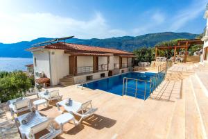 a house with a swimming pool next to the water at Medimar Hotel in Kaş