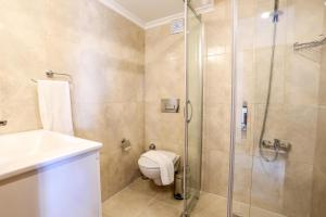 a bathroom with a shower and a toilet and a sink at Medimar Hotel in Kaş +28 photos