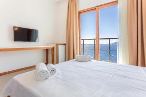 a bedroom with a white bed with a large window at Medimar Hotel in Kaş