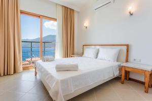 a bedroom with a large bed and a large window at Medimar Hotel in Kaş