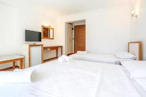 a hotel room with two beds and a tv at Medimar Hotel in Kaş