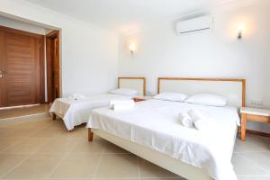 two beds in a room with white walls at Medimar Hotel in Kaş