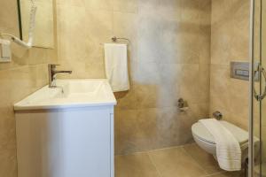 a bathroom with a white toilet and a sink at Medimar Hotel in Kaş