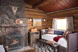 a living room with a fireplace in a log cabin at Lone Mountain Ranch in Big Sky