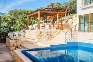 a pool with a gazebo next to a house at Medimar Hotel in Kaş