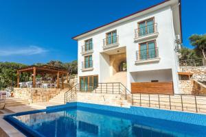 a house with a swimming pool in front of a building at Medimar Hotel in Kaş