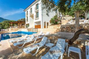 a group of lounge chairs next to a swimming pool at Medimar Hotel in Kaş