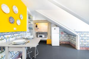 eine Küche mit einem weißen Tisch und einer gelben Wand in der Unterkunft WHome | Sé Skyline Apartment in Lissabon
