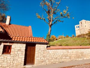 a stone building with a tree and a castle at Serce miasta in Kazimierz Dolny