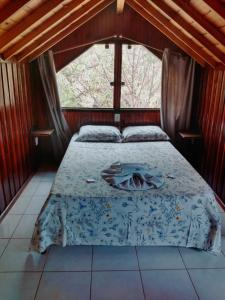 a bedroom with a bed in a room with a window at Pousada Pantanal da Serra in Serra do Cipo