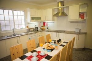 a kitchen with a table and chairs and a sink at BRUMA HOSTEL in Ponta Delgada