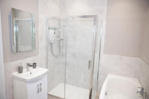 uma casa de banho com um chuveiro, um WC e um lavatório. em Victoria Apartments em Torquay