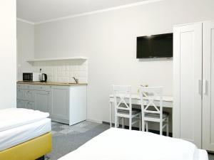a white room with a kitchen and a table and chairs at Apartamenty ZZ in Obryta