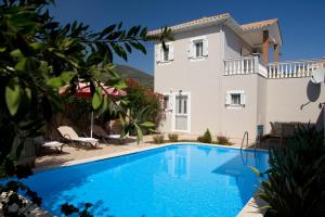 a villa with a swimming pool in front of a house at Le Torri Villas by Nidri holiday villas in Nydri