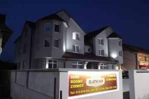 a large white house with a sign in front of it at Zlatni San in Banja Koviljača