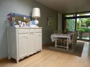 sala de estar con mesa y armario blanco en B&B Sparrow's Nest, en Gante