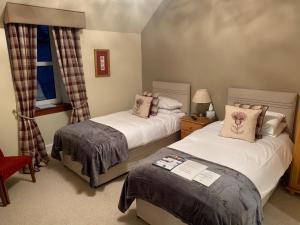 um quarto com 2 camas e uma janela em Drumdale Bed and Breakfast em Inverness