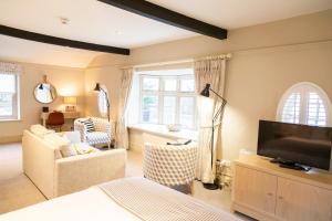 a living room with a television and a couch at The White Horse Blakeney in Blakeney