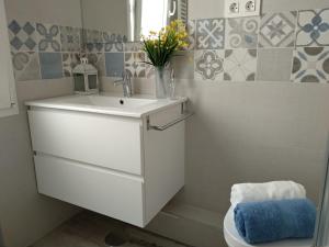 a bathroom with a white sink and a toilet at El Cedro Llorón in Ávila +18 photos