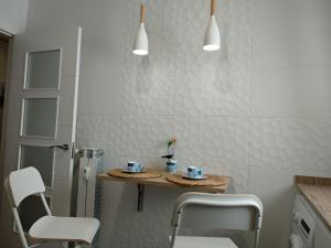 a bathroom with two chairs and a table with cups on it at El Cedro Llorón in Ávila
