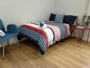 a bedroom with a bed and a blue chair at El Cedro Llorón in Ávila