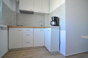 a kitchen with white cabinets and a refrigerator at Belvedere Studio in Tulcea